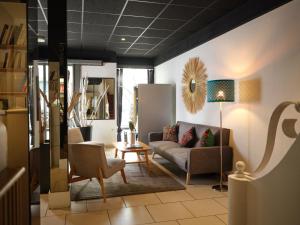 a living room with a couch and a table at Hôtel de Lyon in Valence