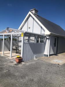 un edificio bianco con un garage con un tavolo di Riverside a Doonbeg
