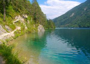 a large body of water with a mountain at Landhaus Vogel in Weissensee