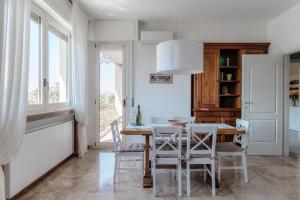 a white dining room with a table and chairs at Villa del Sole - Lake Como Garden in Cernobbio