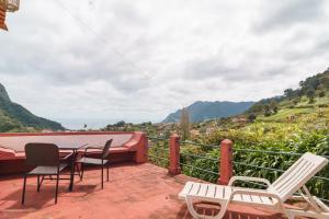 un balcone con tavolo e sedie e vista di GuestReady – Rustic Charm in Peaceful Madeira a Porto da Cruz