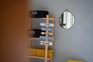 uno scaffale con dei cartelli accanto a uno specchio di GuestReady – Rustic Charm in Peaceful Madeira a Porto da Cruz