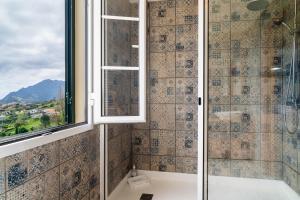 bagno con doccia e finestra di GuestReady – Rustic Charm in Peaceful Madeira a Porto da Cruz