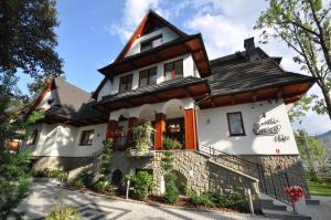 a white house with a brown roof at Willa Kmicic in Zakopane