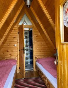 two beds in a room with a attic at Smaka Brvnare in Sjenica