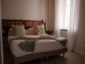 a bedroom with a large bed with pillows and a window at Casa Melox in Lezzeno