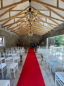 a room with white tables and chairs and a red carpet at Kruger Maroela Lodge in Marloth Park