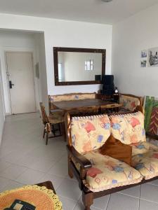 Una sala de estar con dos sofás y un espejo. en Maravilhoso Apto Beira-Mar Prainha, Caraguatatuba com Piscina e Sauna, en Caraguatatuba