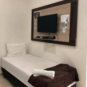 una camera con letto e TV a schermo piatto a parete di Carnaúba Palace Hotel a Campo Maior