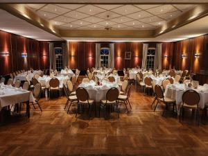 a banquet hall with white tables and chairs at Rodes Hotel und Restaurant in Rehburg-Loccum +24 photos