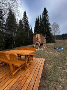 a wooden deck with a picnic table and a cabin at Maringotka pod Babiou horou in Oravská Polhora