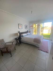 a bedroom with a bed and a chair and a window at kennington lodge in East London