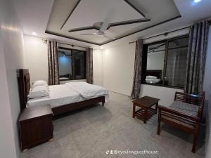 a bedroom with a bed and a ceiling fan at EYE VIEW GUEST HOUSE skardu in Skardu +3 photos