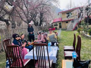a group of women sitting at tables in a yard at EYE VIEW GUEST HOUSE skardu in Skardu
