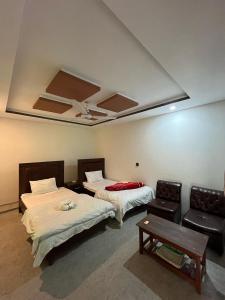 a room with two beds and a table and a couch at EYE VIEW GUEST HOUSE skardu in Skardu