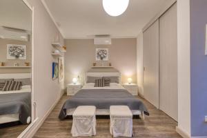 a bedroom with a large bed and two chairs at Central + Bright Apartment in St. Julians in St. Julianʼs