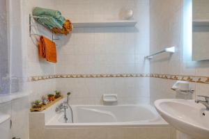 a white bathroom with a tub and a sink at Central + Bright Apartment in St. Julians in St. Julianʼs