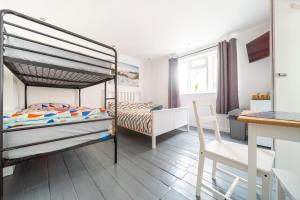 a bedroom with a bunk bed and a desk at Tolcarne Guest House in Newquay