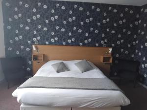 a bedroom with a bed with a black and white wallpaper at Hôtel de Tessé in Bagnoles de l'Orne