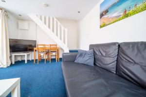 a living room with a gray couch and a table at Tolcarne Guest House in Newquay