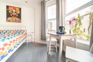 a bedroom with a bed and a desk and a window at Tolcarne Guest House in Newquay