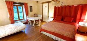 a bedroom with a bed and a table and a window at La Grande Vesvre in Gigny +9 photos