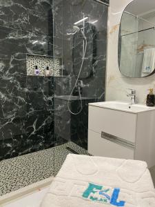 a bathroom with a shower and a sink and a mirror at F&L Relax Mamaia Nord -Apartament cu parcare gratuită in Mamaia Sat/Năvodari