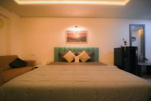 une chambre avec un grand lit et un canapé dans l'établissement The Starlit Stays-Modern Studio, à Jaipur