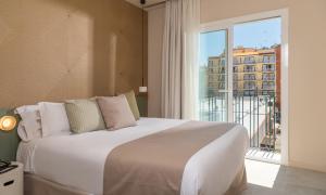 a bedroom with a large bed and a large window at AQUA Hotel Bertran Park in Lloret de Mar +37 photos
