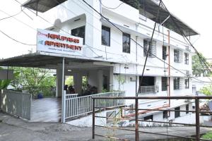 a white building with a sign on it at Nirupama,Hotel Aluva 700 Mtr From Aluva Railway Station in Alwaye