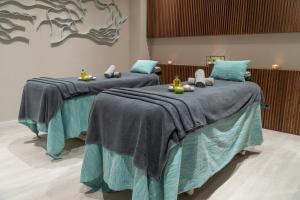 two beds in a room with blue blankets at Hotel Verde Mar & SPA in Ribeira Grande
