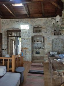 a kitchen with a table and a stone wall at Stone house 1883 Kymi with pool in Enoría