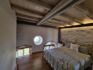 a bedroom with a bed in a room with a window at Stone house 1883 Kymi with pool in Enoría +41 photos