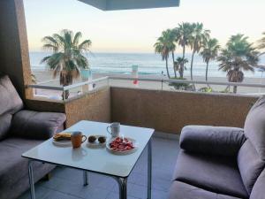 a table with a plate of food on a balcony with the beach at Garage Gratis y en la Playa in Almería