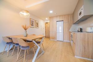 une cuisine et une salle à manger avec une table et des chaises en bois dans l'établissement CARTAGENAFLATS - San Diego Suites, à Carthagène