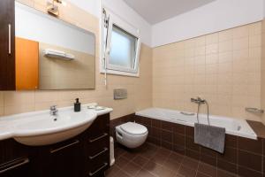 a bathroom with a sink and a tub and a toilet at Agapi Deluxe Villa in Skala Rachoniou +26 photos