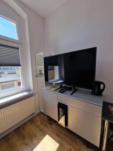 a living room with a large flat screen tv on a dresser at Apartamenty Zakonne "Apartament Rycerza" in Malbork