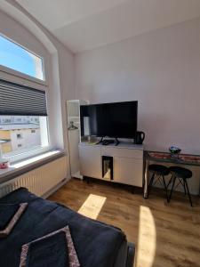 a living room with a flat screen tv and a table at Apartamenty Zakonne "Apartament Rycerza" in Malbork +4 photos