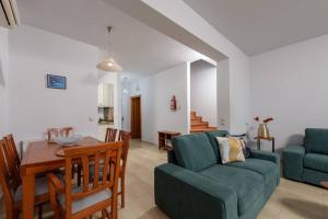 a living room with a blue couch and a table at Agapi Deluxe Villa in Skala Rachoniou