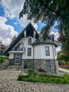 a white building with a black roof at Pine Peak in Predeal