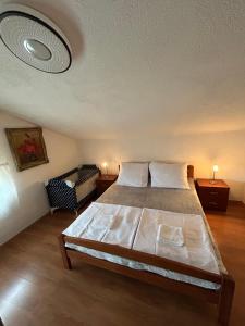 ein Schlafzimmer mit einem Bett und einem Stuhl darin in der Unterkunft Apartments Marina in Sukošan