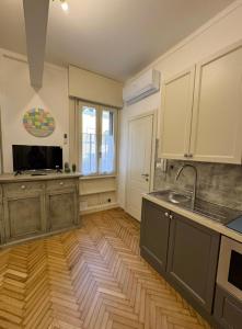 a kitchen with a wooden floor and a sink and a counter at Aro's House in Cremona