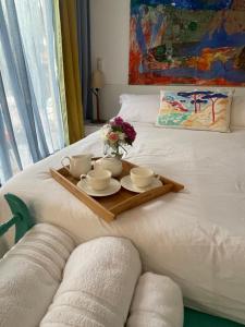 a tray with cups and saucers on a bed at Le petit studio in Calonge +65 photos