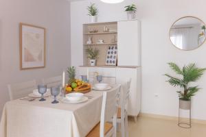 ein weißes Esszimmer mit Tisch und Stühlen in der Unterkunft Comeback DONT WORRY BE HAPPY in Salobreña