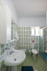 サランダにあるDuraj Apartmentの洗面台とトイレを備えた白いバスルーム