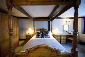 a bedroom with a large wooden bed and a desk at White Hart, Exeter by Marston's Inns in Exeter