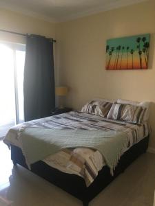 a bedroom with a bed with a painting on the wall at Villa Blanca in Strand