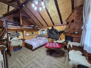 a bedroom in a log cabin with a bed and a fireplace at Căbănuța Cocoțată in Rucăr