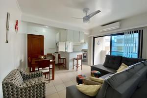 a living room with a couch and a table and a kitchen at SHB - The Jewel Pitangueiras with complete leisure in Guarujá