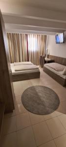 a living room with two beds and a rug at Bach Hotel in Porta Westfalica